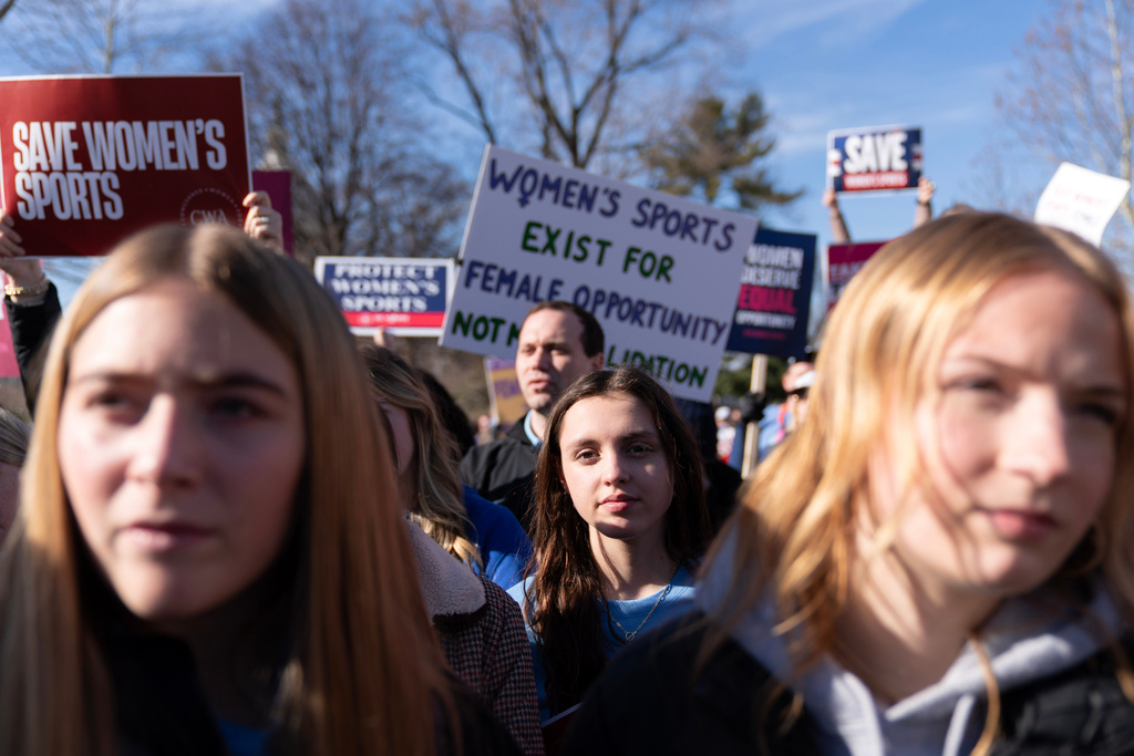 Protesters gather outside the Supreme Court as it hears arguments over state laws barring transgender girls and women from playing on school athletic teams, Tuesday, Jan. 13, 2026, in Washington. (AP Photo/Jose Luis Magana)