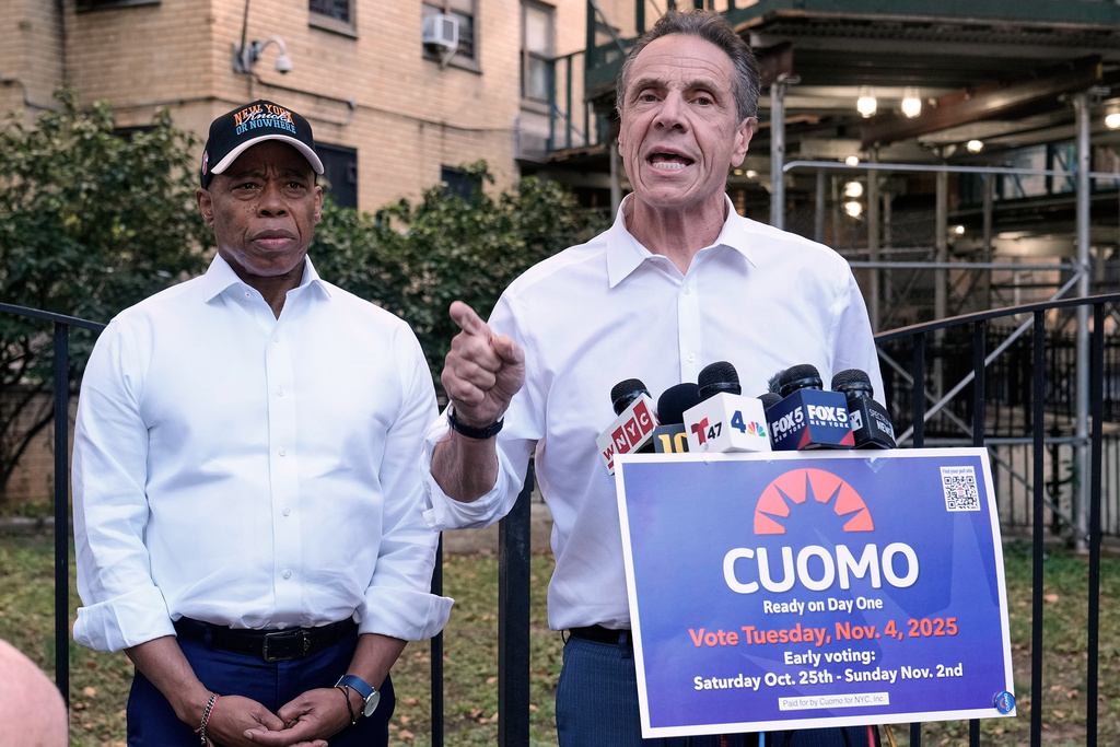 New York Mayor Eric Adams, left, and Democrat mayoral candidate Andrew Cuomo appear at a campaign event outside the George Washington Carver Houses, in New York, Thursday, Oct. 23, 2025. (AP Photo/Richard Drew)
