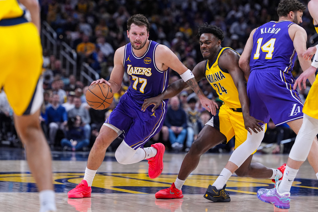 Los Angeles Lakers guard Luka Doncic (77) drives past Indiana Pacers guard Kobe Brown (24) during the second half of an NBA basketball game in Indianapolis, Wednesday, March 25, 2026. (AP Photo/Michael Conroy)