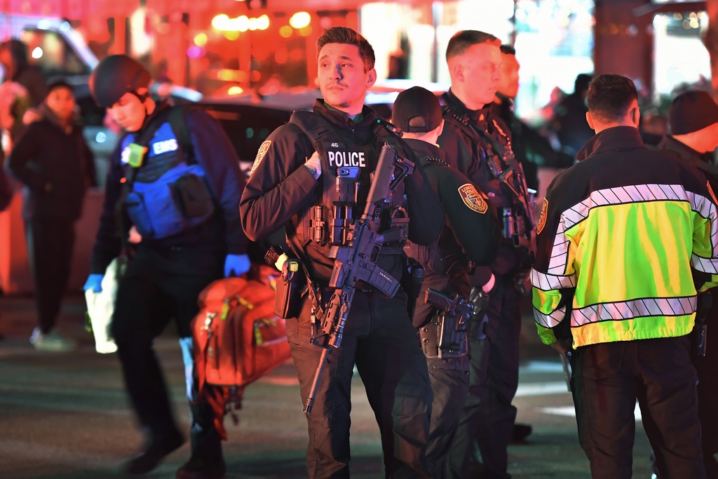 Law enforcement officials carrying weapons gather near Brown University in Providence, R.I., on Saturday, Dec. 13, 2025, during the investigation of a shooting. (AP Photo/Steven Senne)