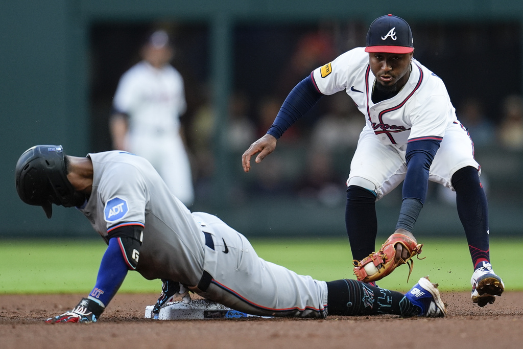 Miami Marlins' Otto Lopez (6) gets to second base on his double against Atlanta Braves' Ozzie Albies (1) in the second inning of a baseball game, Thursday, Aug. 7, 2025, in Atlanta. (AP Photo/Mike Stewart)