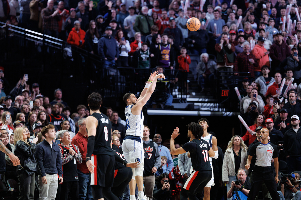 Dallas Mavericks guard Klay Thompson, middle, shoots during the second half of an NBA basketball game against the Portland Trail Blazers Monday Dec. 29, 2025, in Portland, Ore. (AP Photo/Howard Lao)