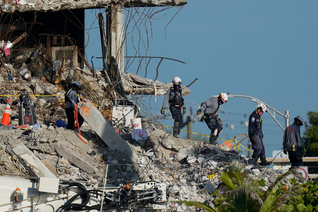 FILE - Search and rescue workers descend from the rubble pile at the Champlain Towers South condo building, July 2, 2021, in Surfside, Fla. (AP Photo/Mark Humphrey, File)