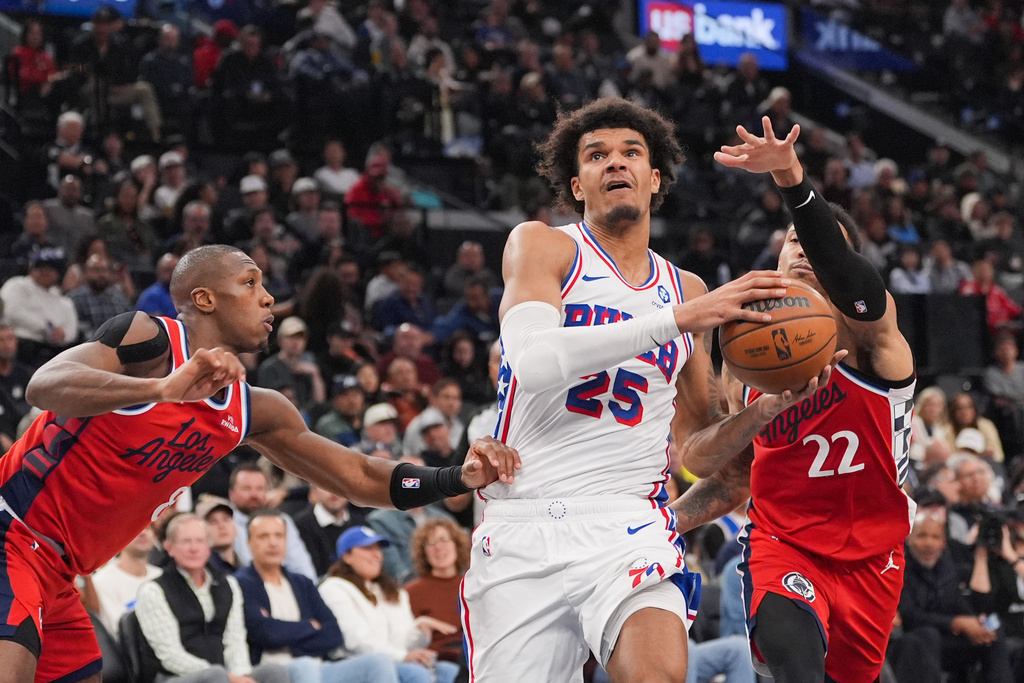 Philadelphia 76ers forward Dominick Barlow (25) drives to the basket past Los Angeles Clippers guard Jordan Miller (22) and guard Kris Dunn (8) during the first half of an NBA basketball game Monday, Feb. 2, 2026, in Inglewood, Calif. (AP Photo/Jae C. Hong)