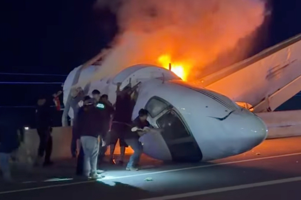 People attempt to pull passengers out of a plane after it crashed on a highway Tuesday, June 16, 2026, in Laredo, Texas. (Zayra Garza via AP)