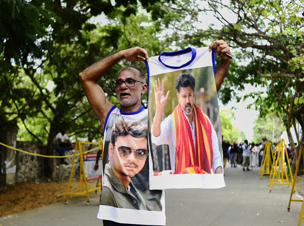 A worker of Tamilaga Vettri Kazhagam (TVK) party displays the photographs of party leader and actor-turned-politician, Vijay Chandrasekhar as he celebrates the early leads and results in the recently held state election, in Chennai, southern Indian state of Tamil Nadu, Monday, May 4, 2026. (AP Photo)