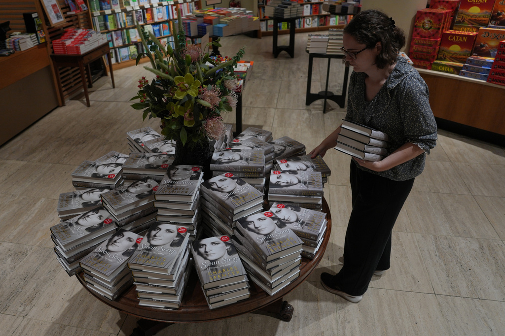 A member of staff put out copies of the new book by Earl Spencer, brother of the late Princess Diana, entitled "Swan Song: Diana, My Sister," on sale in a bookshop in central London, Tuesday, Sept. 22, 2026. (AP Photo/Kin Cheung)