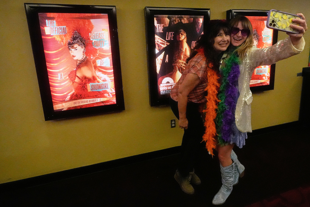 Amy Davis, left, and Jenni Boyer take photos before the official release of Taylor Swift's new album, "The Life of a Showgirl," at the AMC Metreon in San Francisco, Friday, Oct. 3, 2025. (AP Photo/Jeff Chiu)