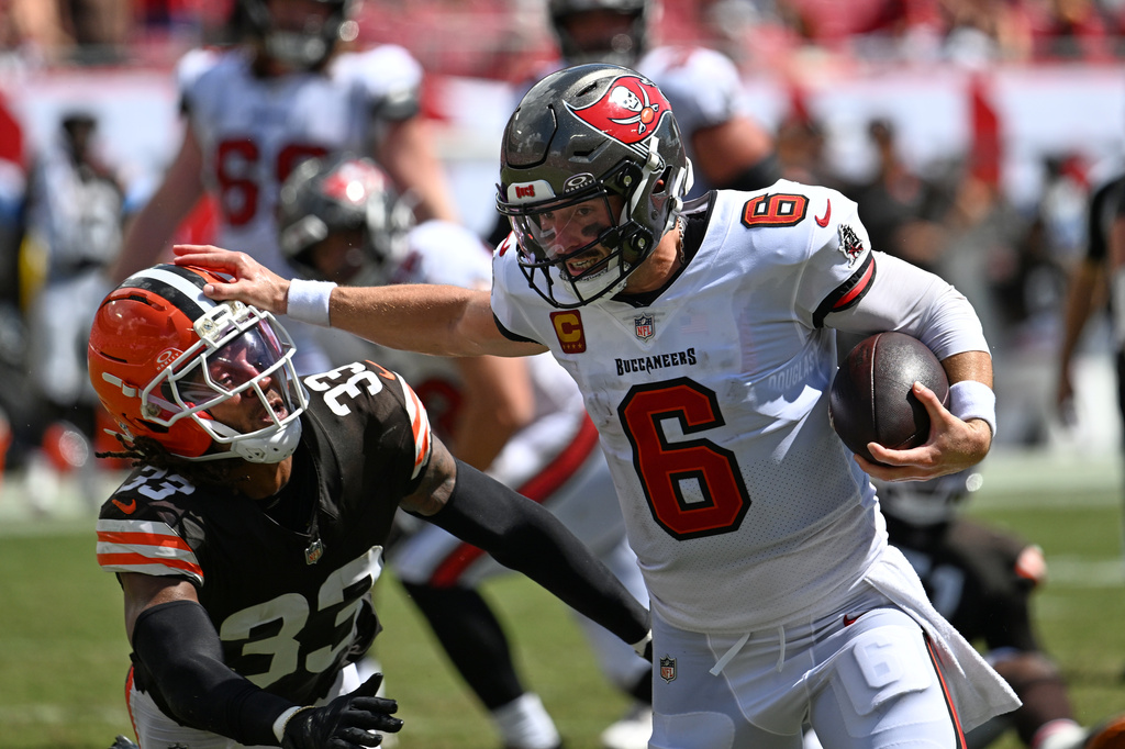 Tampa Bay Buccaneers quarterback Baker Mayfield (6) scrambles for a first down as Cleveland Browns safety Ronnie Hickman (33) defends during the second half of an NFL football game in Tampa, Fla., Sunday, Sept. 20, 2026. (AP Photo/Jason Behnken)