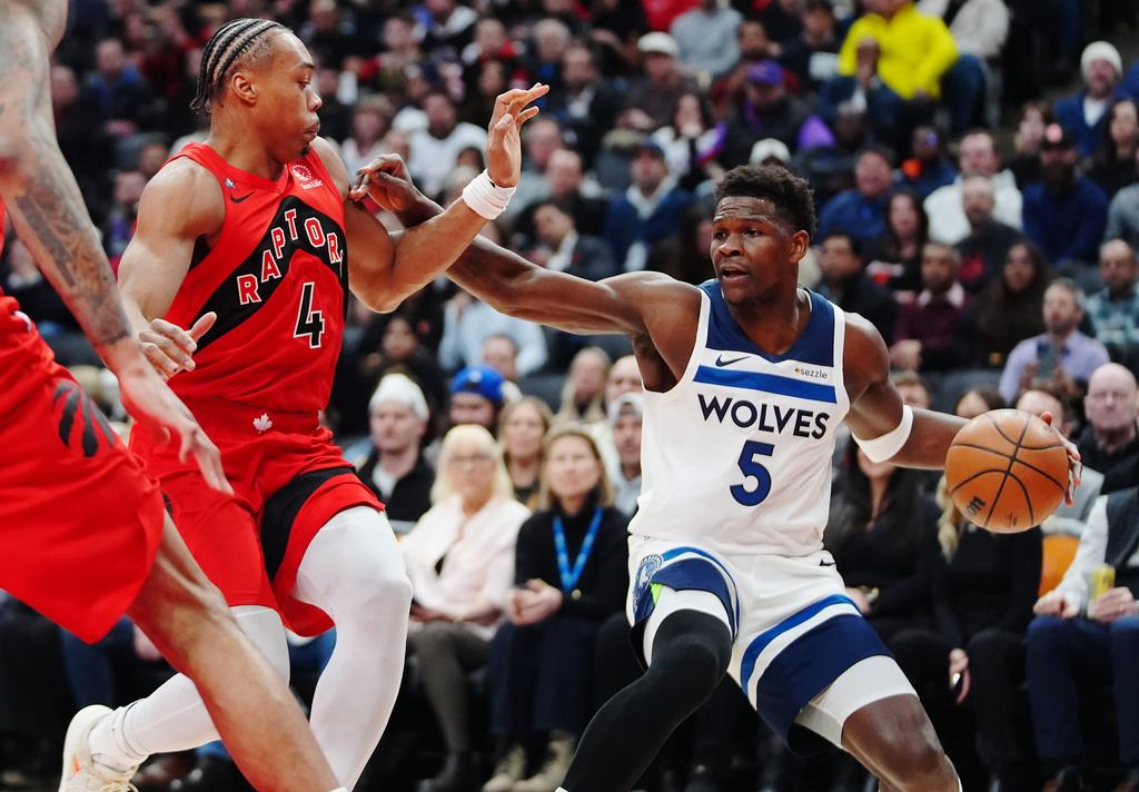 Minnesota Timberwolves' Anthony Edwards (5) protects the ball from Toronto Raptors' Scottie Barnes (4) during the first half of an NBA basketball game in Toronto, Wednesday, Feb. 4, 2026. (Frank Gunn/The Canadian Press via AP)