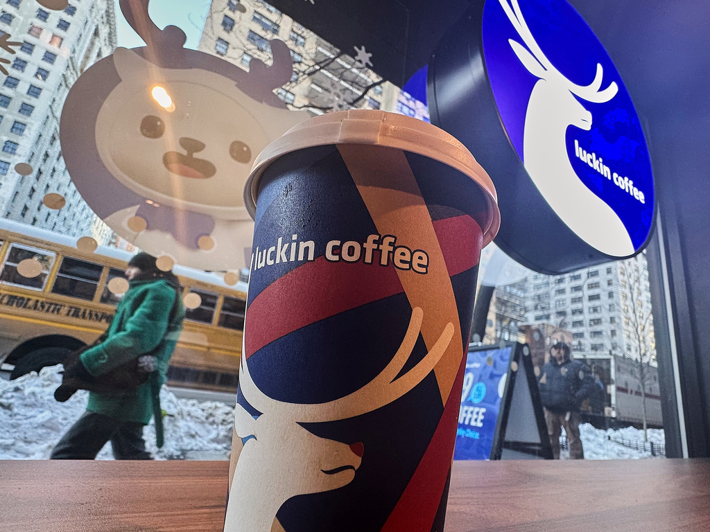 Signage displays in the window and a cup sits on the counter of a Luckin Coffee store in New York, Friday, Jan. 30, 2026. (AP Photo/Richard Drew)