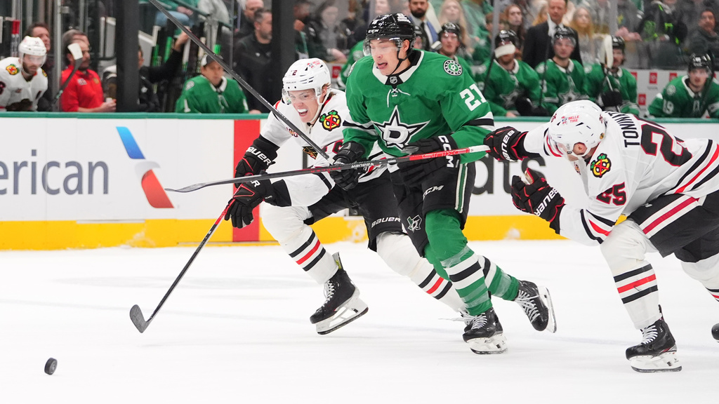Dallas Stars left wing Jason Robertson (21) skates for the puck against Chicago Blackhawks center Dominic Toninato (25) and defenseman Alex Vlasic during the first period of an NHL hockey game Saturday, Dec. 27, 2025, in Dallas. (AP Photo/LM Otero)