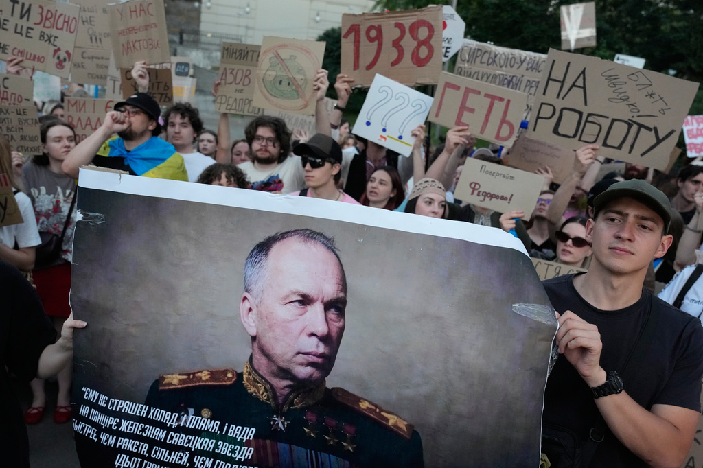 Activists hold a portrait of Ukraine's Armed Forces Commander-in-Chief Oleksandr Syrskyi demanding his resignation during a rally to denounce President Volodymyr Zelenskyy's decision to dismiss Defense Minister Mykhailo Fedorov after six months in the post, in Kyiv, Ukraine, Saturday, July 18, 2026. (AP Photo/Efrem Lukatsky)