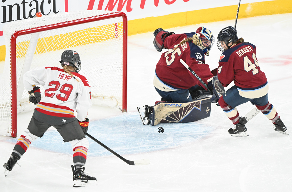 Ottawa Charge's Peyton Hemp (29) moves in on Montreal Victoire goaltender Ann-Renee Desbiens (35) as Victoire's Amanda Boulier (44) defends during second period PWHL hockey action in Laval, Que., Tuesday, Jan. 13, 2026. (Graham Hughes/The Canadian Press via AP)