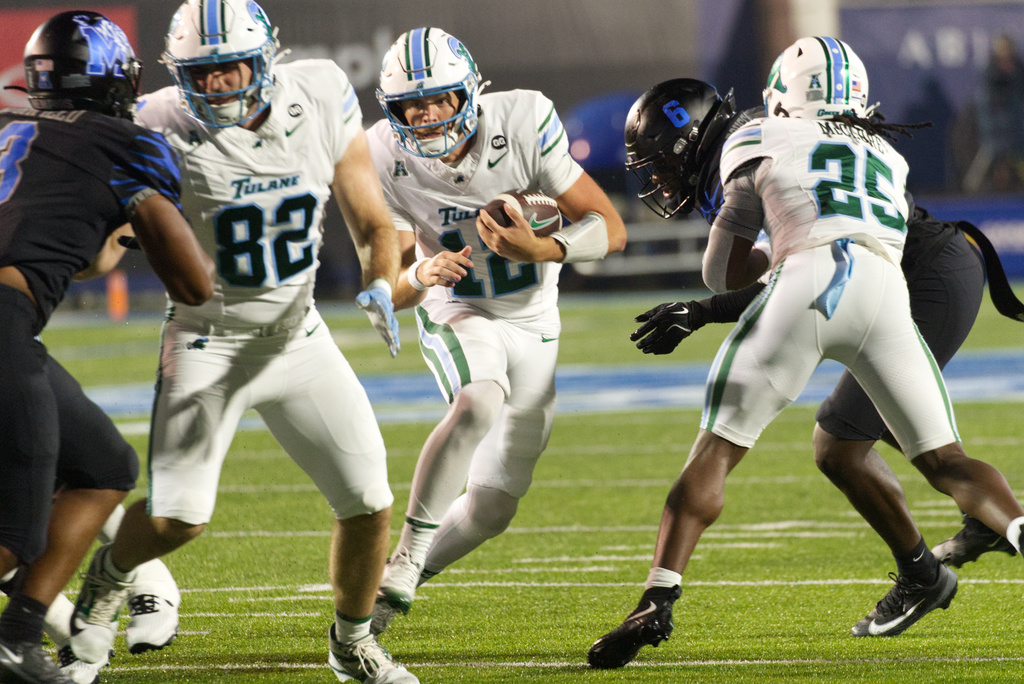 Tulane quarterback Jake Retzlaff (12) carries the ball through a hole as Tulane tight end Johnny Pascuzzi (82) blocks Memphis linebacker Sam Brumfield, left, and Tulane running back Jamauri McClure (25) blocks Memphis linebacker Everett Roussaw Jr. (6) during the first half of an NCAA college football game, Friday, Nov. 7, 2025, in Memphis, Tenn. (AP Photo/Nikki Boertman)