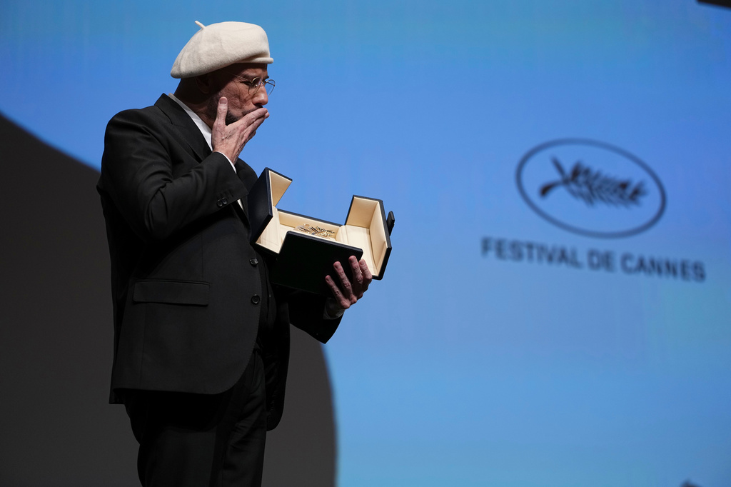 John Travolta holds his honorary Palme d'Or during the 79th international film festival, Cannes, southern France, Friday, May 15, 2026. (Photo by Scott A Garfitt/Invision/AP)