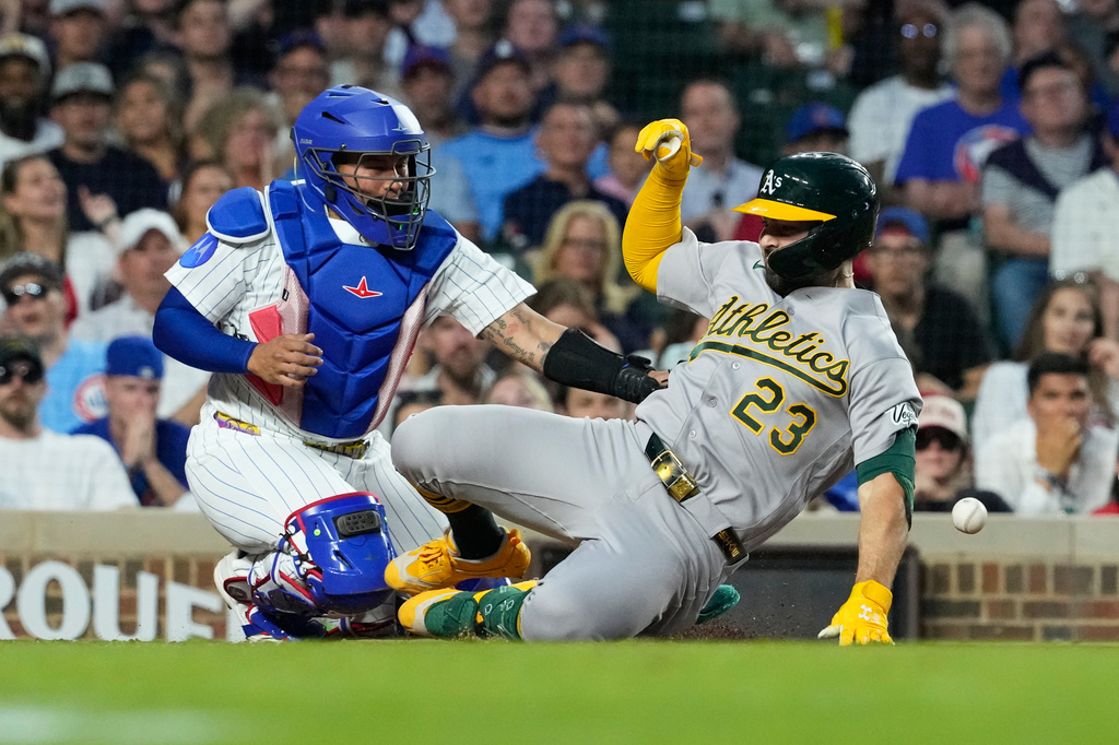 Athletics' Shea Langeliers, right, slides into home after hitting a two-run inside-the-park home run as Chicago Cubs catcher Moisés Ballesteros waits for the ball during the sixth inning of a baseball game against the Chicago Cubs in Chicago, Thursday, June 4, 2026. (AP Photo/Nam Y. Huh)