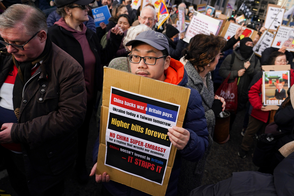 Demonstrators hold placards and flags as they attend a protest against the proposed Chinese embassy, in London, Saturday, Jan. 17, 2026. (AP Photo/Alberto Pezzali)