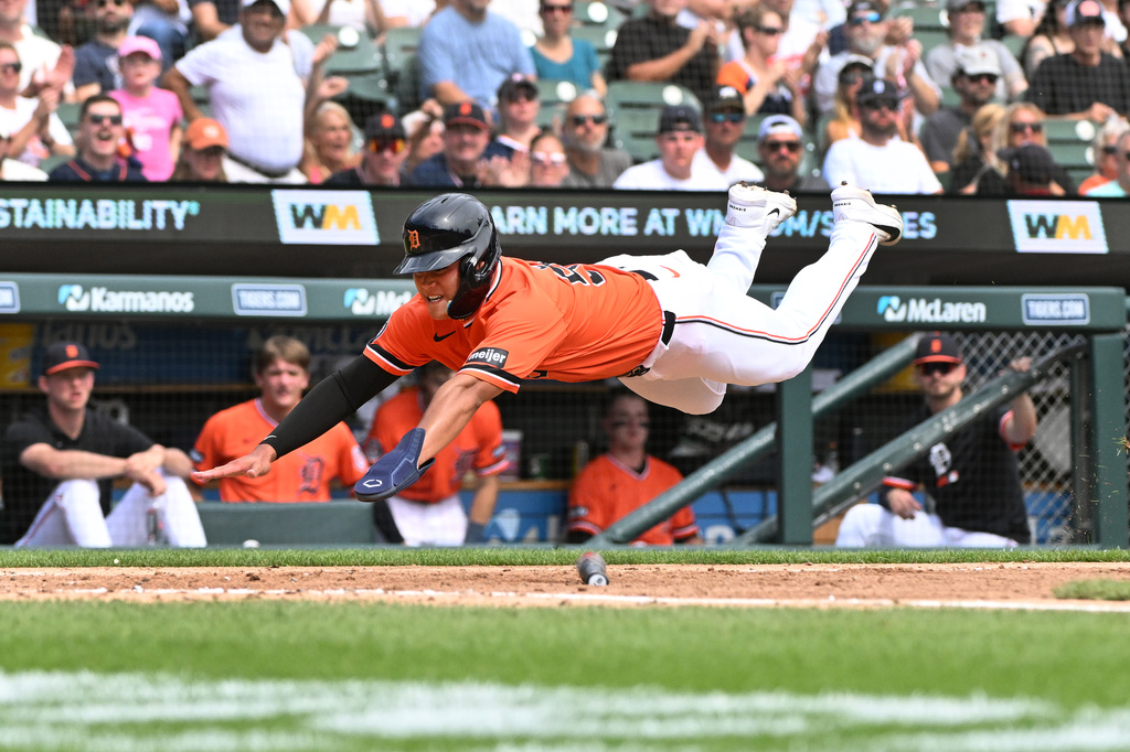 Detroit Tigers' Hao-Yu Lee dives towards home plate and scores a run during the fourth inning of a baseball game against the Colorado Rockies, Saturday, Sept. 12, 2026, in Detroit. (AP Photo/Jose Juarez)