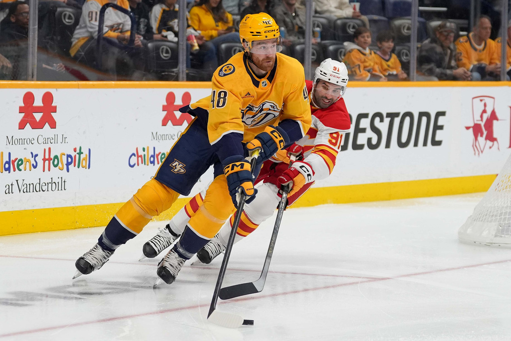 Nashville Predators defenseman Nick Perbix (48) moves the puck against Calgary Flames center Nazem Kadri (91) during the first period of an NHL hockey game Saturday, Nov. 1, 2025, in Nashville, Tenn. (AP Photo/Camden Hall)
