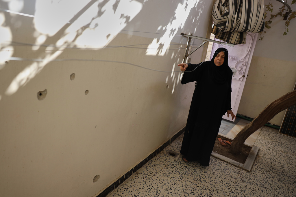 Sabah al-Sheikh al-Kilani, the mother of Khaled al-Masoud, points to bullet holes in the wall of her son's home after he was killed during a raid in the town of al-Dumayr, in the Damascus countryside, Syria, Oct. 28, 2025. (AP Photo/Omar Albam)