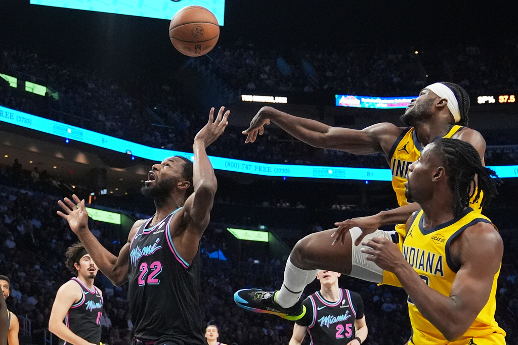 Miami Heat forward Andrew Wiggins (22) attempts a shot as Indiana Pacers forward Jarace Walker, right, rear, defends during the first half of an NBA basketball game, Saturday, Dec. 27, 2025, in Miami. (AP Photo/Lynne Sladky)