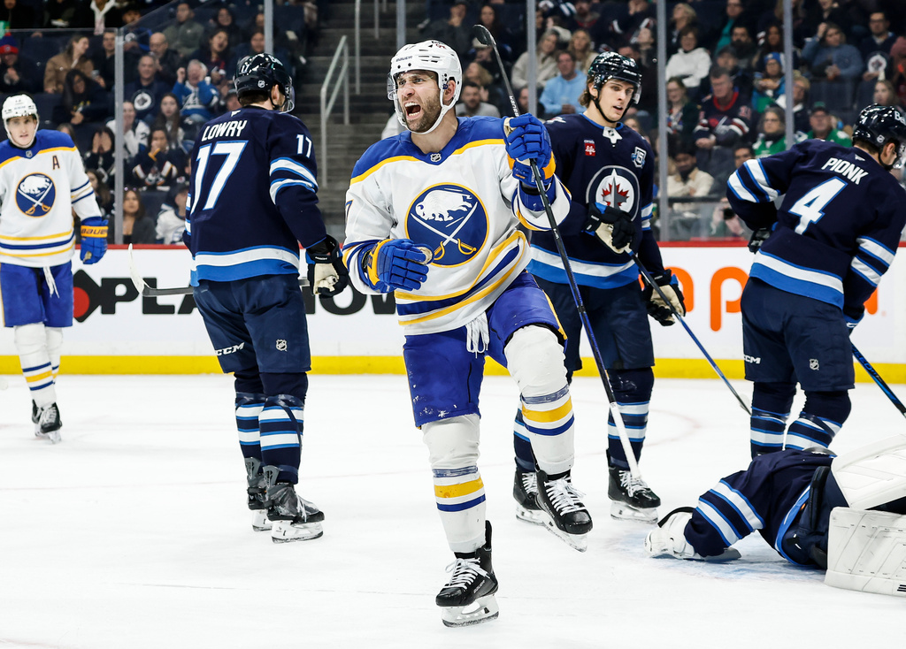 Buffalo Sabres' Jason Zucker (17) celebrates his goal against Winnipeg Jets goaltender Eric Comrie (1) during first period NHL action in Winnipeg on Friday, Dec. 5, 2025. (John Woods/The Canadian Press via AP)