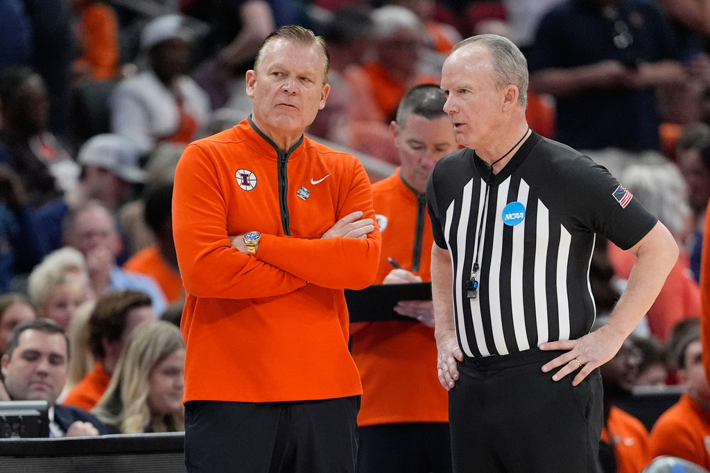 Illinois coach Brad Underwood listens to an official during a timeout to fix a broken horn during the first half of an Elite Eight game against Iowa in the NCAA college basketball tournament Saturday, March 28, 2026, in Houston. (AP Photo/Ashley Landis)