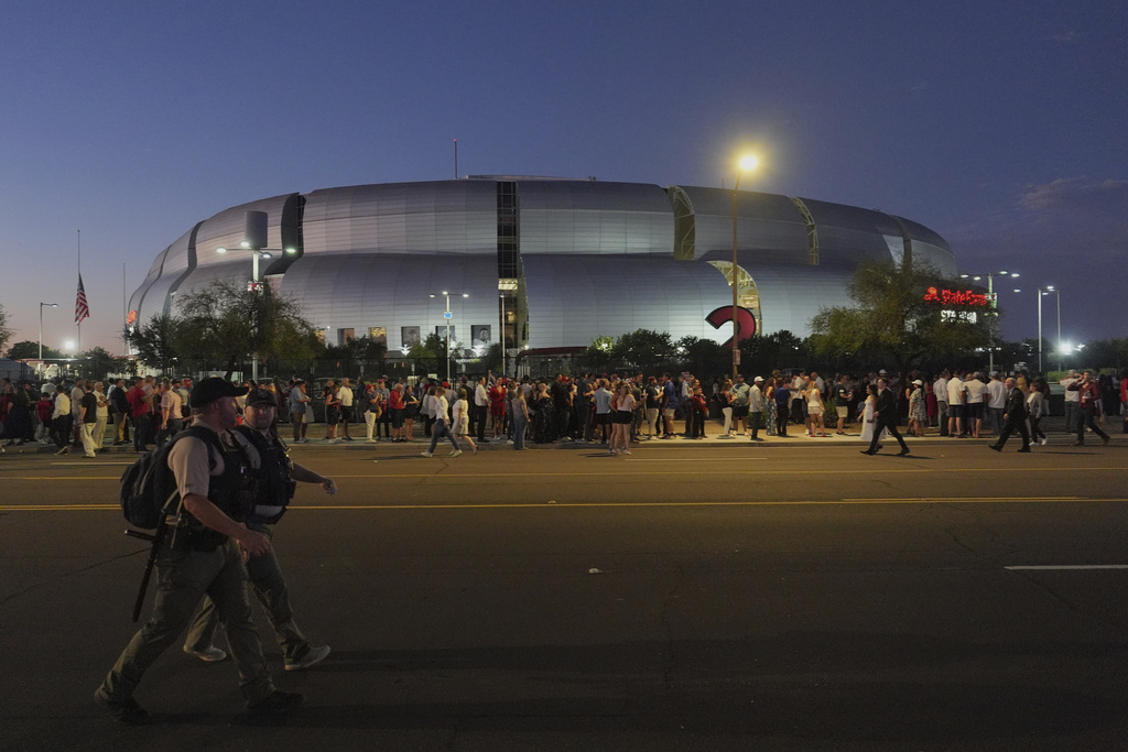People wait in line before a memorial for conservative activist Charlie Kirk Sunday, Sept. 21, 2025, at State Farm Stadium in Glendale, Ariz. (AP Photo/Jae C. Hong)