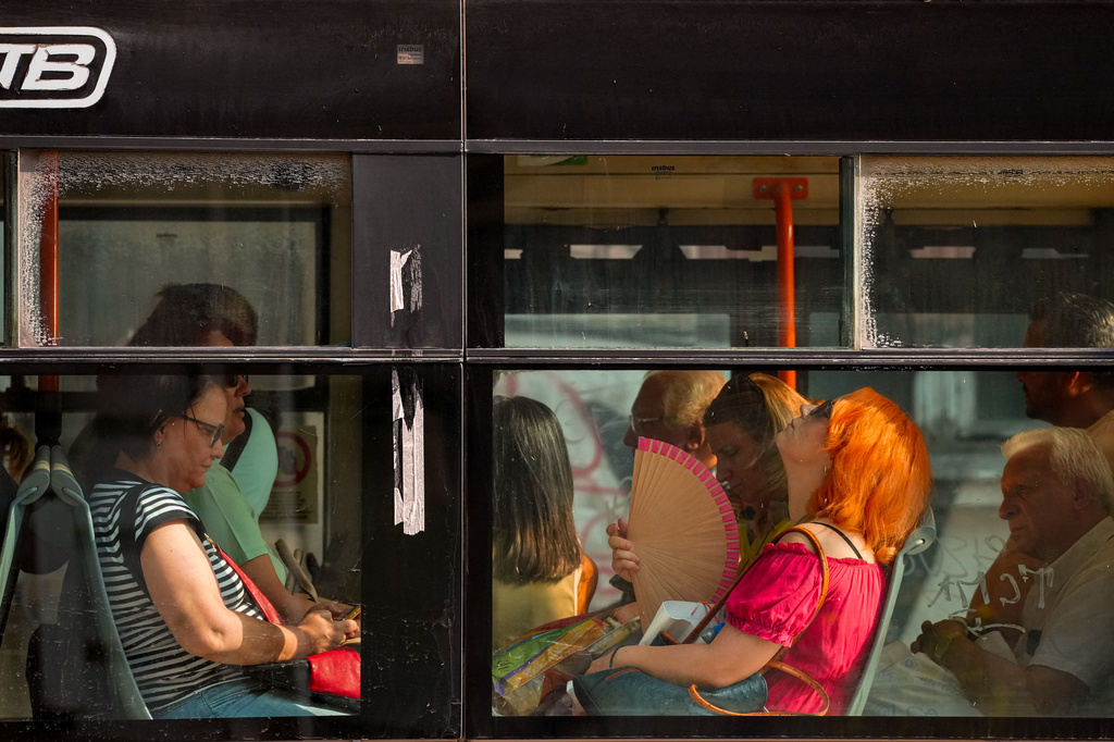 A woman uses a fan to cool off while riding a bus on a hot day, as the National Weather forecaster issued an extreme heat code red warning for most parts of the country, in Bucharest, Romania, Thursday, Aug. 6, 2026. (AP Photo/Vadim Ghirda)