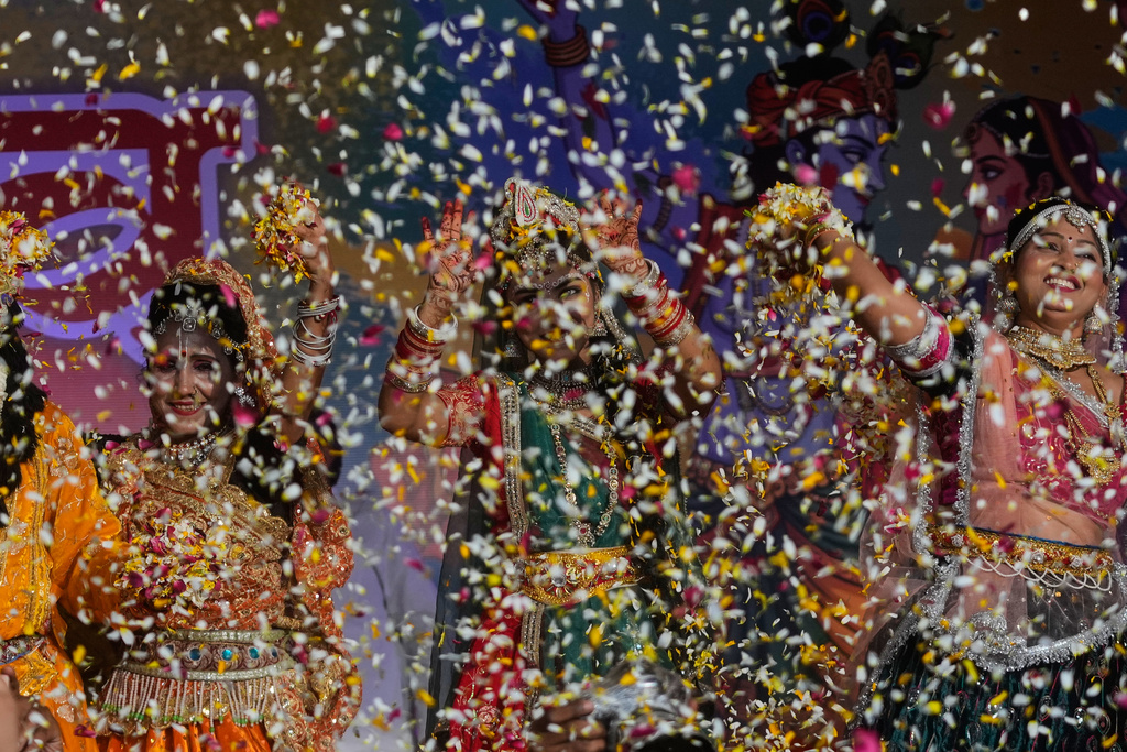 Artists dressed as the Hindu deities Lord Krishna and Radha throw flower petals during Holi festival celebrations at the Shri Krishna Janmabhoomi Temple complex in Mathura, India, on Feb. 27, 2026. (AP Photo/Manish Swarup)