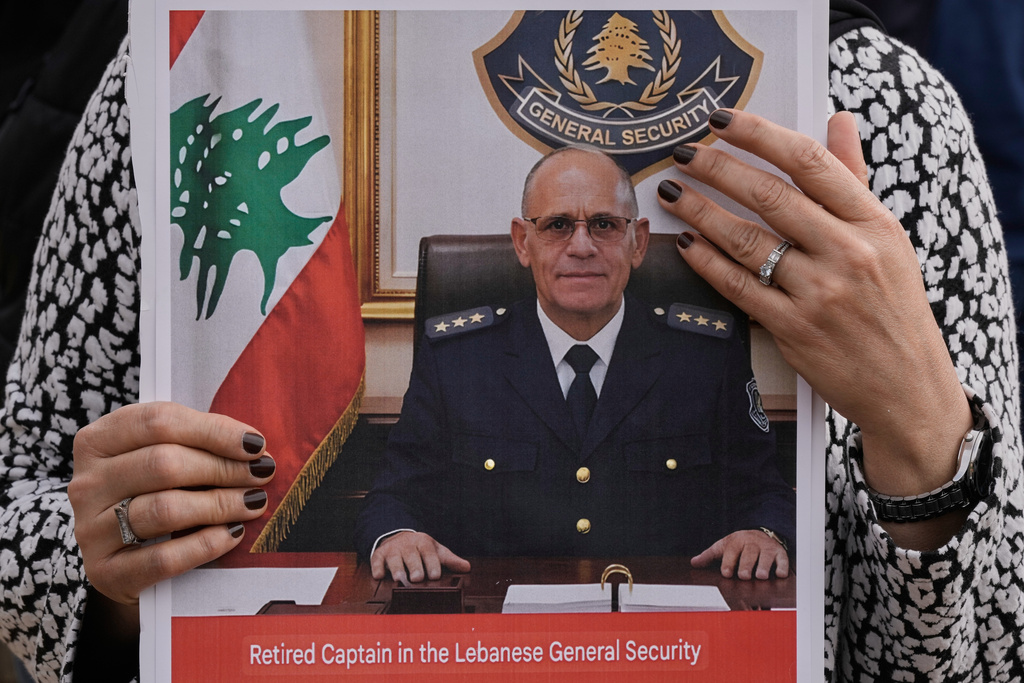 A relative of retired Lebanese officer Ahmed Shukr, holds a poster of him during a gathering outside the headquarters of the U.N. Economic and Social Commission for Western Asia, ESCWA, in Beirut, Lebanon, Friday, Feb. 13, 2026. (AP Photo/Bilal Hussein)