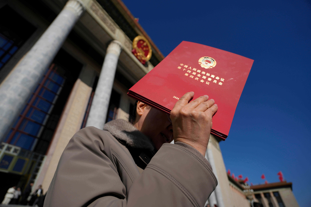 A delegate holds up a red folder as she leaves after the closing ceremony of the Chinese People's Political Consultative Conference (CPPCC), in Beijing, Wednesday, March 11, 2026. (AP Photo/Ng Han Guan)
