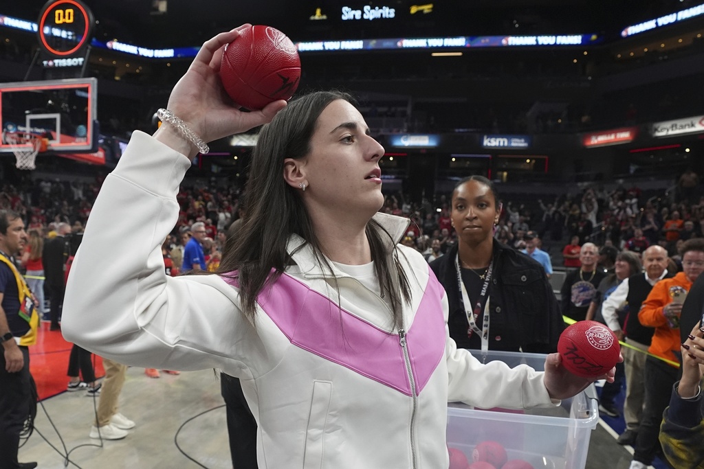 Indiana Fever's Caitlin Clark tosses a mini autographed basketball to fans following a WNBA basketball game against the Minnesota Lynx, Tuesday, Sept. 9, 2025, in Indianapolis. (AP Photo/Darron Cummings)