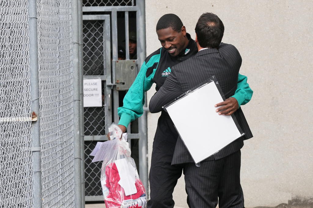 Former NFL star wide receiver Antonio Brown, left, greets his attorney Mark Russell Eiglarsh, right, after being released from the Turner Guilford Knight Correctional Center, Thursday, Nov. 13, 2025, in Miami. (AP Photo/Lynne Sladky)