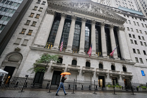 A woman with an umbrella passes the New York Stock Exchange, Monday, Oct. 13, 2025. (AP Photo/Richard Drew) A woman with an umbrella passes the New York Stock Exchange, Monday, Oct. 13, 2025. (AP Photo/Richard Drew)