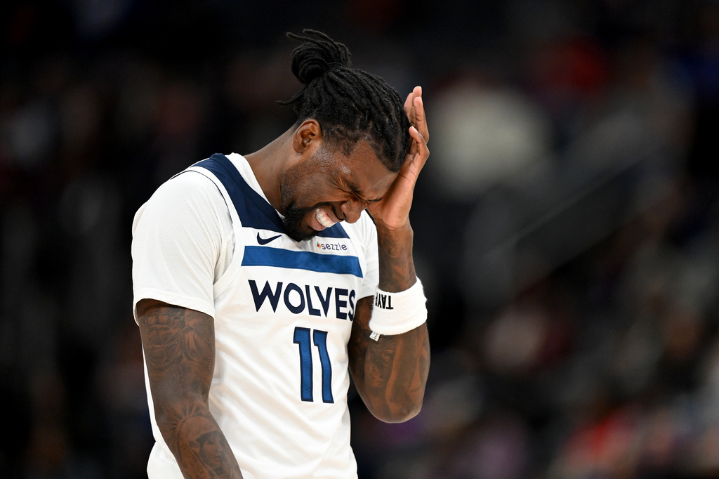 Minnesota Timberwolves center Naz Reid (11) reacts after bumpin heads with Detroit Pistons forward Ronald Holland II in the first half of an NBA basketball game Thursday, April 2, 2026, in Detroit. (AP Photo/Lon Horwedel)