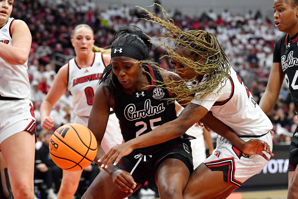 Louisville guard Skylar Jones, center right, tips the ball away from South Carolina guard Raven Johnson (25) during the second half of an NCAA college basketball game in Louisville, Ky., Thursday, Dec. 4, 2025. (AP Photo/Timothy D. Easley)