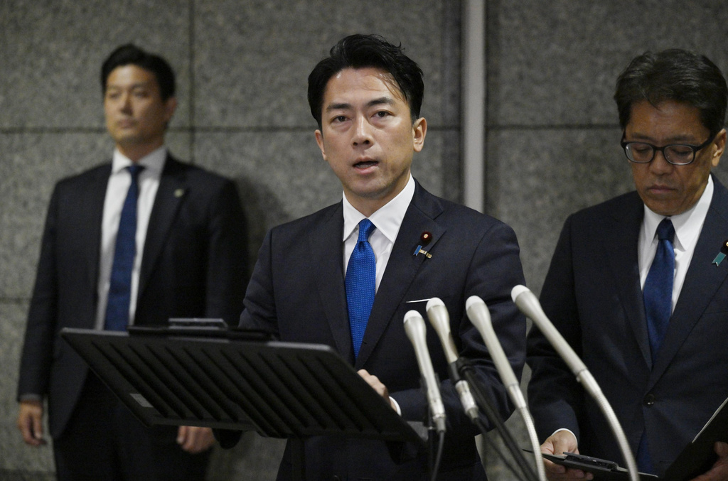 Japan's Defense Minister Shinjiro Koizumi, center, speaks to the media, as Japan announced that a Chinese military aircraft locked its radar on Japanese jets, at the ministry in Tokyo, Sunday, Dec. 7, 2025. (Kyodo News via AP)