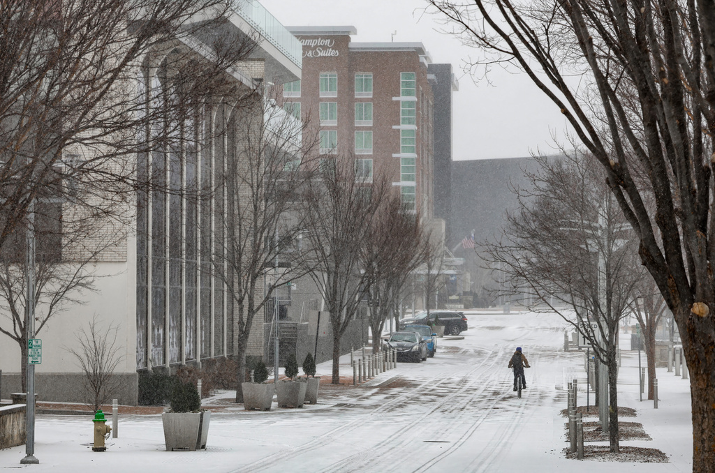 A bicyclist rides in the snow along Veterans Blvd. as a winter storm passes though the area Saturday, Jan. 24, 2026, in Owensboro, Ky. (Greg Eans/The Messenger-Inquirer via AP)