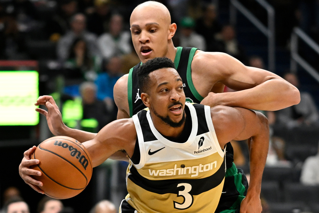 Washington Wizards guard CJ McCollum (3) dribbles past Boston Celtics guard Jordan Walsh to the basket during the first half of an NBA basketball game Thursday, Dec. 4, 2025, in Washington. (AP Photo/John McDonnell)