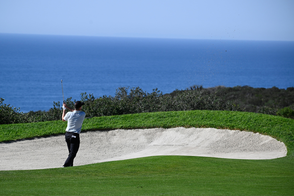 Justin Rose, of England, hits out of a bunker on the 14th hole of the South Course at Torrey Pines during the final round of the Farmers Insurance Open golf tournament Sunday, Feb. 1, 2026, in San Diego. (AP Photo/Denis Poroy)