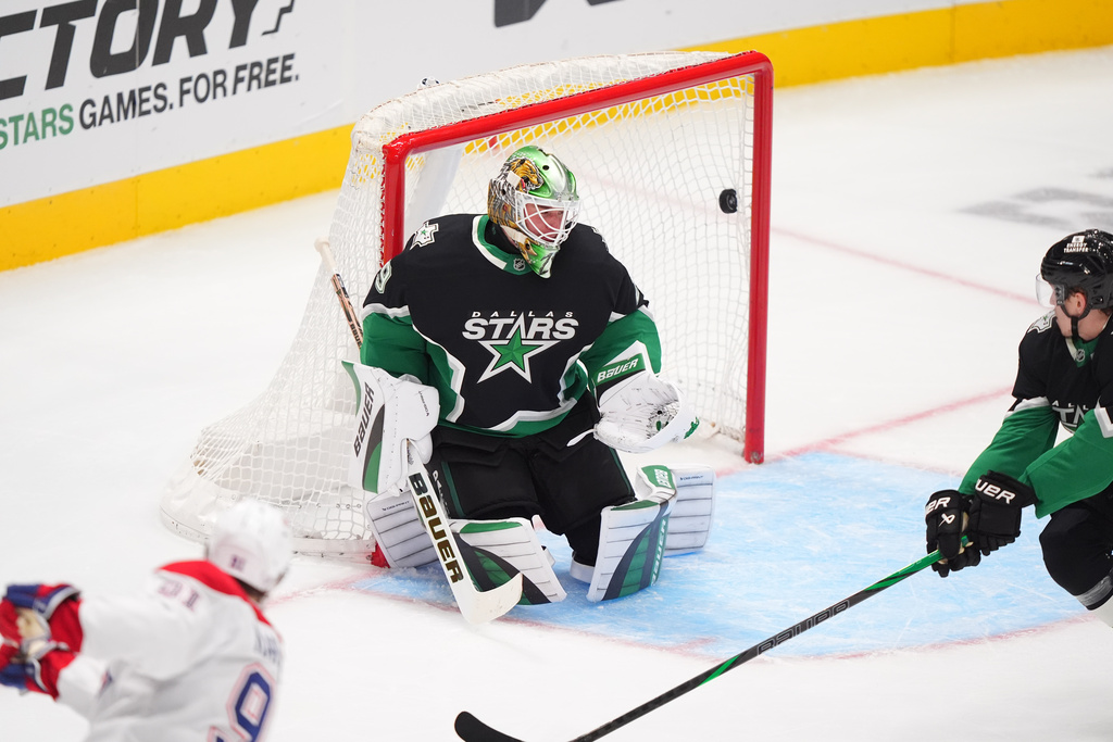 Montréal Canadiens center Oliver Kapanen (91) scores against Dallas Stars goaltender Jake Oettinger, center, and defenseman Nils Lundkvist, right, during the second period of an NHL hockey game Sunday, Jan. 4, 2026, in Dallas. (AP Photo/LM Otero)