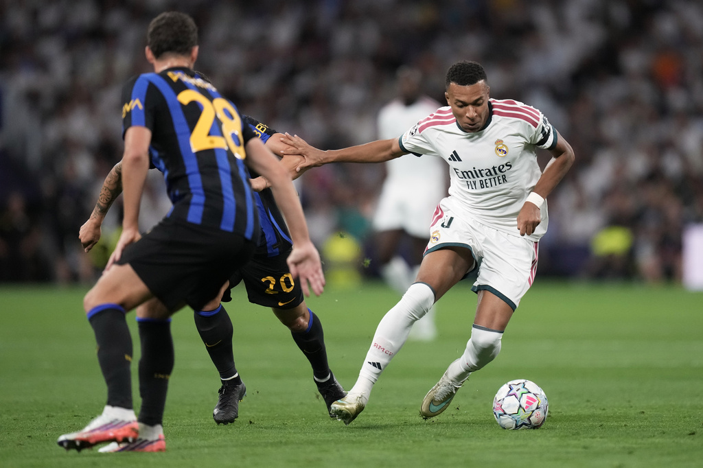Real Madrid's Kylian Mbappe fights for the ball against Inter Milan's Hakan Calhanoglu before scoring the opening goal, during a Champions League soccer match between Real Madrid and Inter Milan in Madrid, Spain, Tuesday, Sept. 8, 2026. (AP Photo/Bernat Armangue)