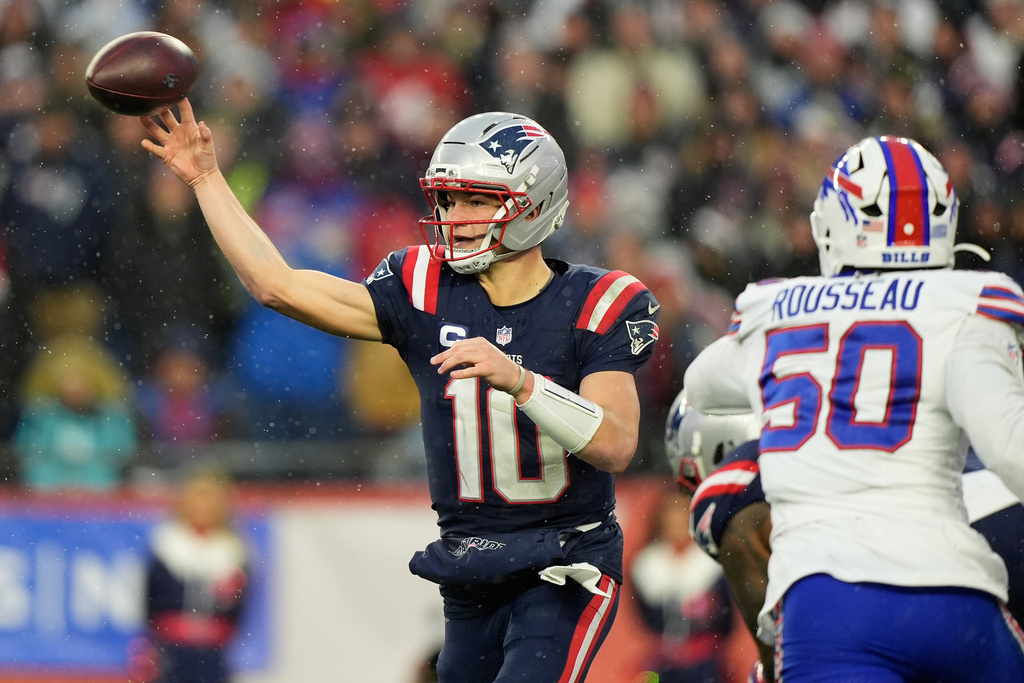 New England Patriots quarterback Drake Maye (10) passes as Buffalo Bills defensive end Greg Rousseau (50) applies pressure during the second half of an NFL football game in Foxborough, Mass., Sunday, Dec. 14, 2025. (AP Photo/Robert F. Bukaty)