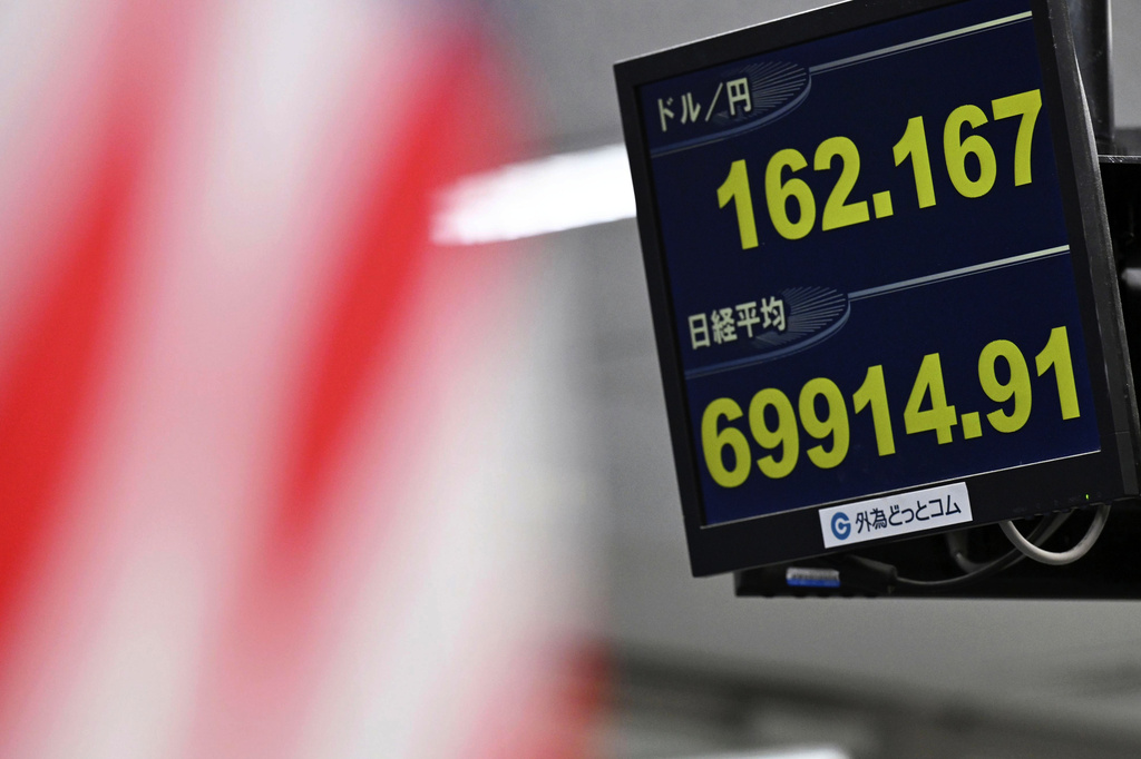 An electronic board shows Japan's benchmark Nikkei 225 index, bottom, and exchange rate of the Japanese yen against the U.S. dollar in Tokyo Tuesday, June 30, 2026. (Kenichiro Kojima/Kyodo News via AP)