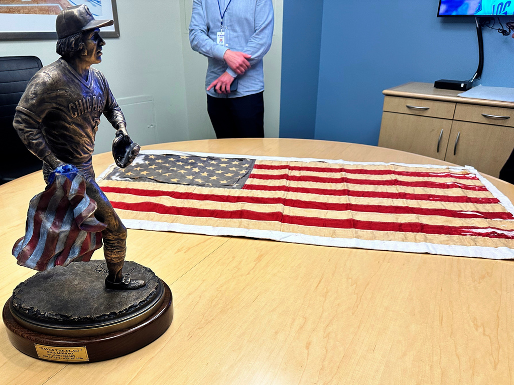 The U.S. flag that Cubs outfielder Rick Monday saved from being burned during a game at Dodger Stadium on April 25, 1976, is displayed on the 50th anniversary along with a bronze sculpture of Monday's rescue that was presented to him Saturday April, 25, 2026. (AP Photo/Beth Harris) Sent from my iPhone