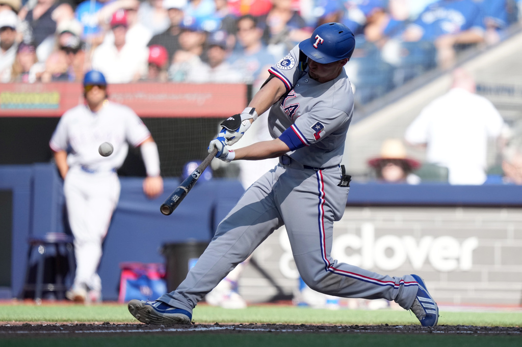 Texas Rangers' Corey Seager hits a solo home run during the sixth inning of a baseball game against the Toronto Blue Jays in Toronto, Saturday, June 27, 2026. (Nathan Denette/The Canadian Press via AP)