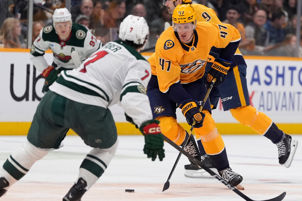 Nashville Predators right wing Michael McCarron (47) skate the puck against Minnesota Wild defenseman Brock Faber (7) during the second period of an NHL hockey game Wednesday, Feb. 4, 2026, in Nashville, Tenn. (AP Photo/George Walker IV)