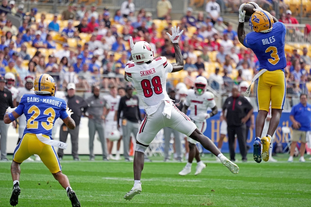 Pittsburgh linebacker Rasheem Biles (3) intercepts a pass by Louisville quarterback Miller Moss intended for Louisville tight end Jaleel Skinner (88) before returning it for a touchdown during the first half of an NCAA college football game in Pittsburgh, Saturday, Sept. 27, 2025. (AP Photo/Gene J. Puskar)